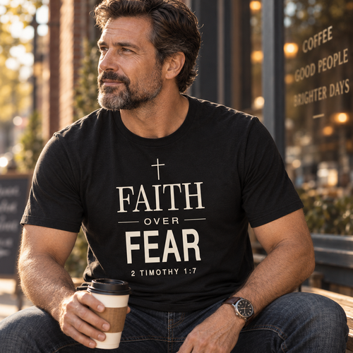 Man seated outdoors wearing Faith Over Fear 2 Timothy 1:7 Christian shirt