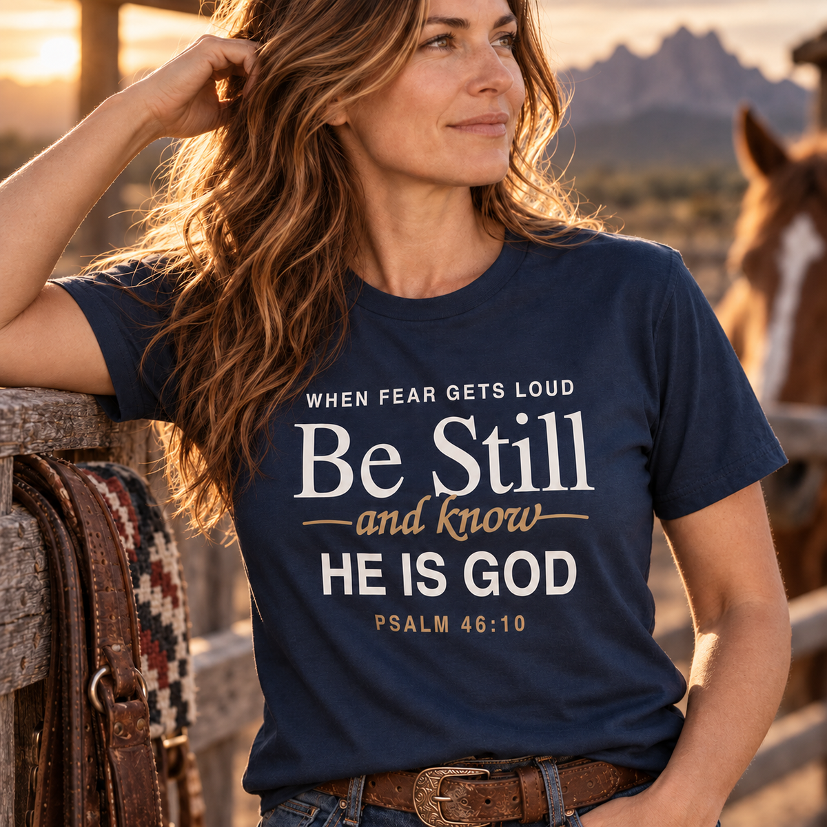 Close-up lifestyle view of woman wearing navy “Be Still and Know He Is God” Psalm 46:10 Christian T-shirt.