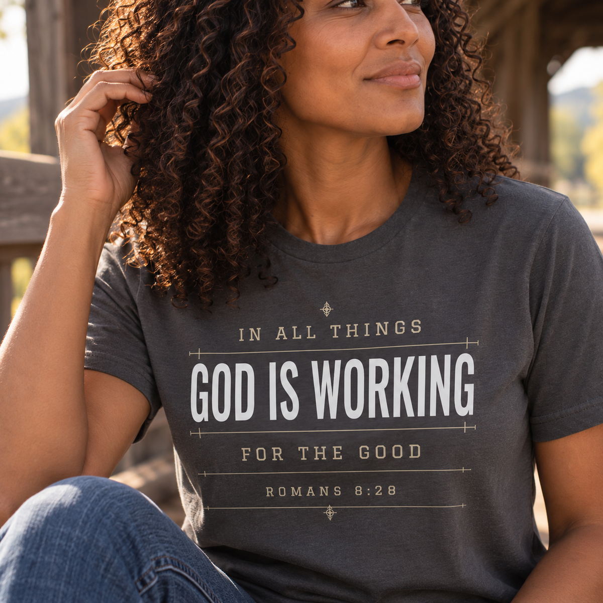 Close-up of graphite Christian T-shirt featuring “In All Things God Is Working for the Good” and Romans 8:28 Scripture artwork.