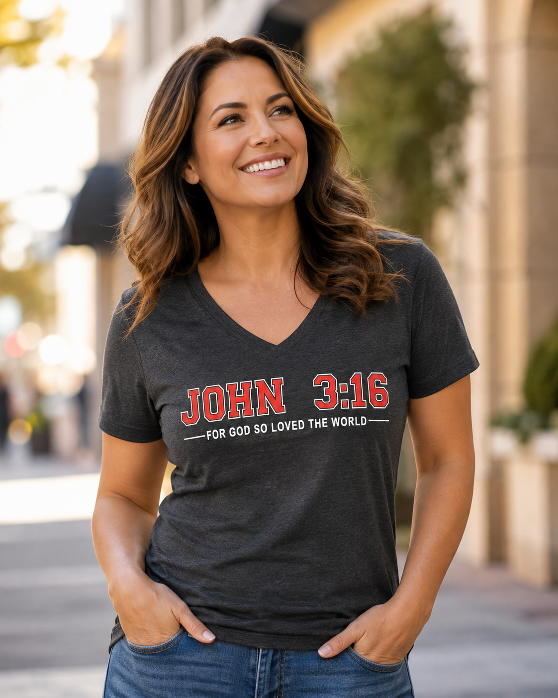 Woman wearing a dark heather John 3:16 Christian V-neck T-shirt with “For God So Loved the World” Scripture design outdoors.