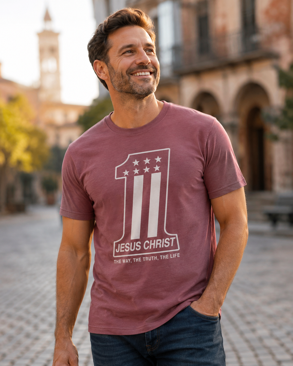 Smiling man wearing a mauve Christian T-shirt featuring a number one design with “Jesus Christ—The Way, the Truth, the Life” while walking outdoors.