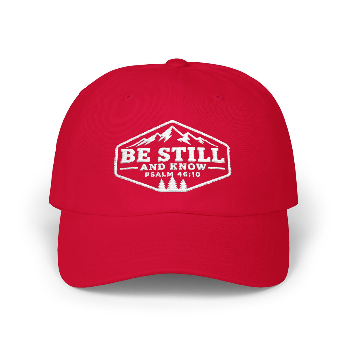 A red baseball cap with a white embroidered graphic on the front that reads 'BE STILL AND KNOW PSALM 46:10' with a mountain and pine tree design, shown on a white background.