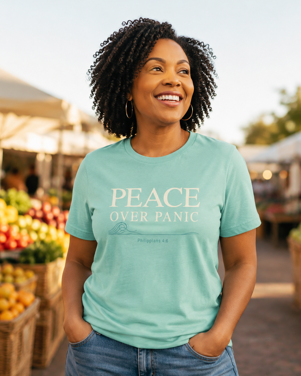 Woman wearing a light aqua Peace Over Panic Christian T-shirt featuring Philippians 4:6 at an outdoor market.