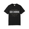 Black Christian T-shirt featuring “In All Things, God Is Working for the Good” with Romans 8:28 on a plain white background.