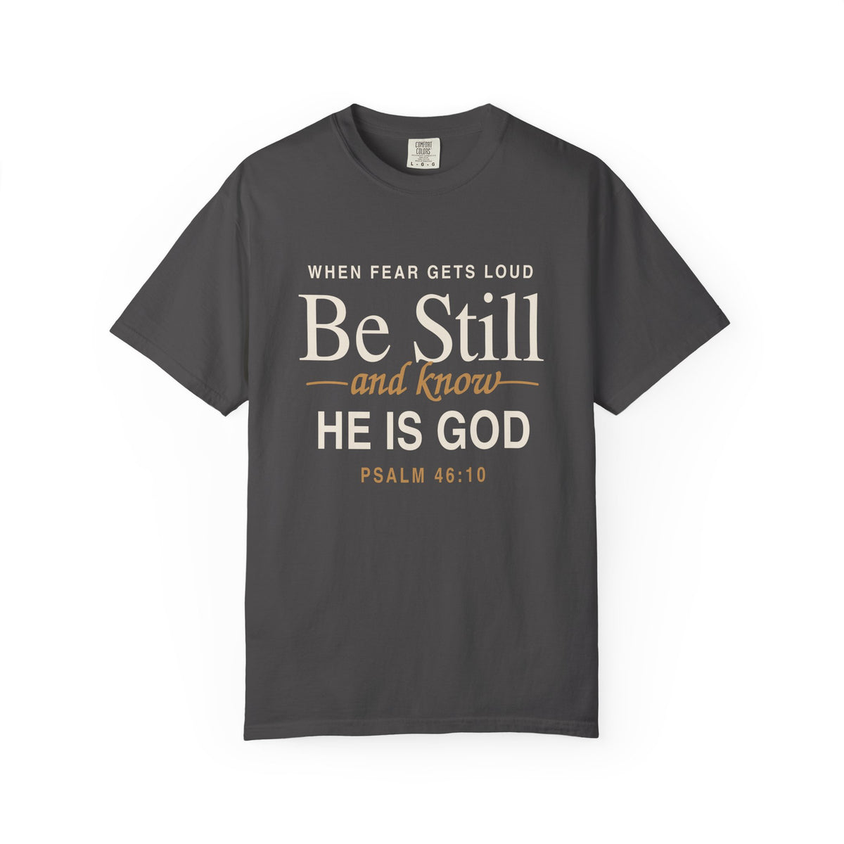 Gray Christian T-shirt reading “When Fear Gets Loud, Be Still and Know He Is God” with Psalm 46:10 on a plain white background.