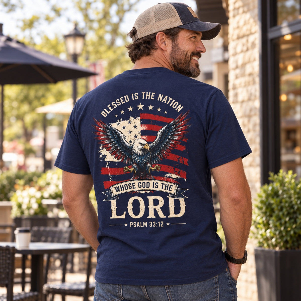 Man wearing navy Blessed Is the Nation Christian T-shirt showing patriotic eagle and Psalm 33:12 back print.