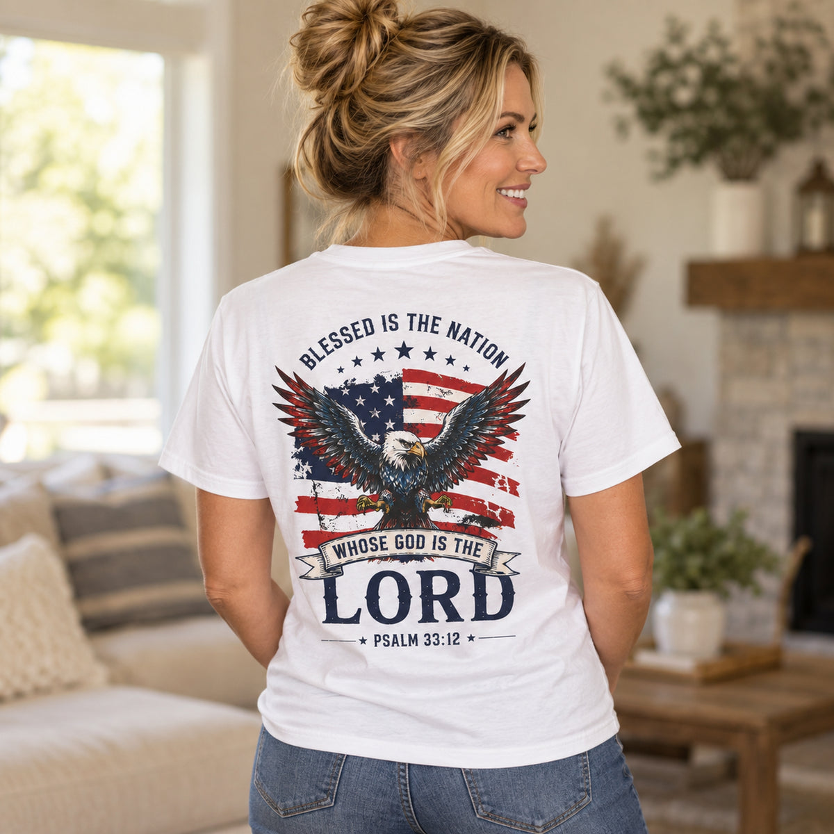 Woman wearing white Blessed Is the Nation Christian T-shirt showing patriotic eagle and Psalm 33:12 back design.