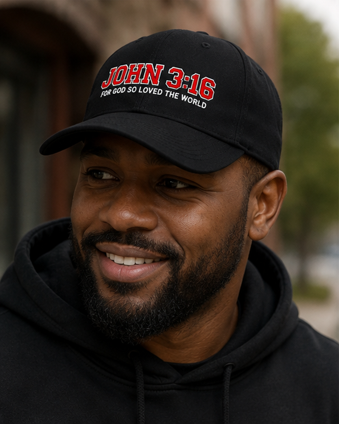 Man wearing black John 3:16 Christian hat with red and white Scripture embroidery outdoors